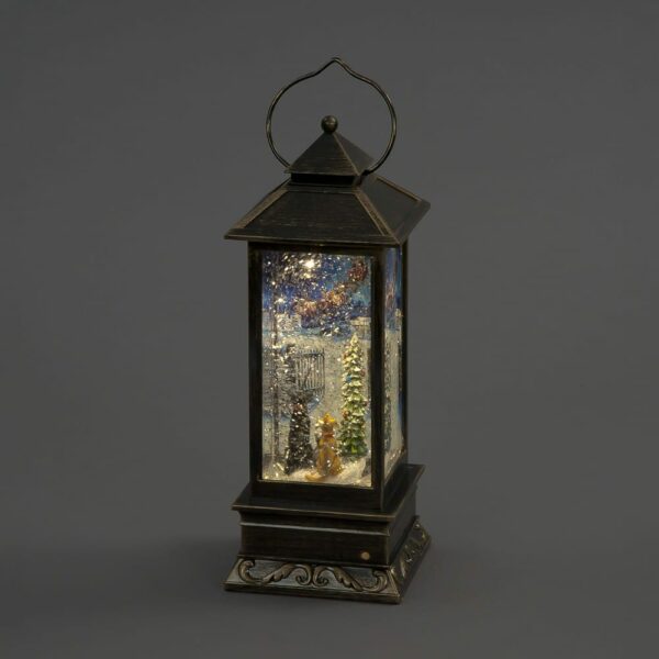 A cat and dog looking at Santa inside a bronze light up lantern with glitter.